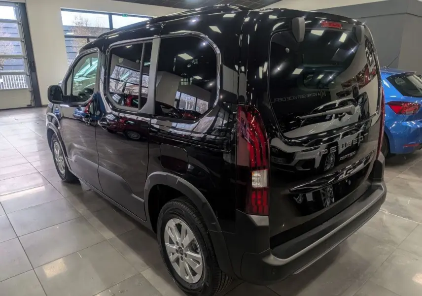 Vue 3/4 arrière droite d’un Peugeot Rifter noir Perla Nera brillant, avec feux arrière verticaux et jantes alliage.