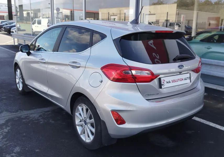 Vue 3/4 arrière droite d'une Ford Fiesta gris lunaire 5 portes, avec feux arrière LED et vitres teintées.