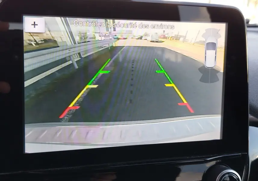 Écran de caméra de recul affichant la vue arrière avec lignes de guidage colorées dans une Ford Fiesta gris lunaire 2019.