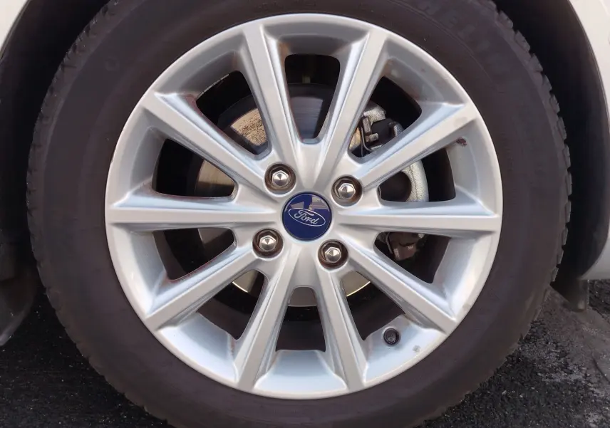 Gros plan sur la jante alliage argentée de la Ford Fiesta gris lunaire, avec logo Ford central visible.