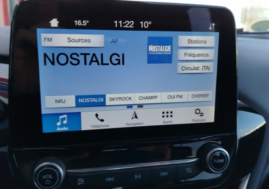Écran tactile central de la Ford Fiesta 2019 affichant la radio sur la station Nostalgie, avec commandes audio visibles.