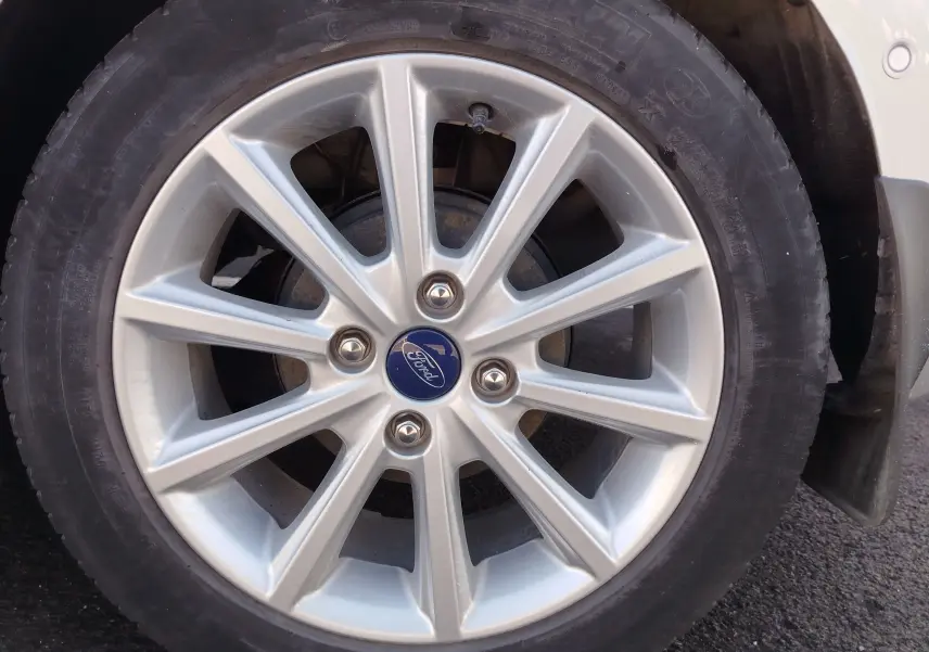 Gros plan sur la jante alliage argentée de la Ford Fiesta gris lunaire, avec logo Ford au centre.