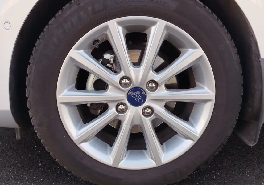 Gros plan sur la roue avant droite d'une Ford Fiesta gris lunaire de 2019 avec jante alliage argentée et logo Ford central.