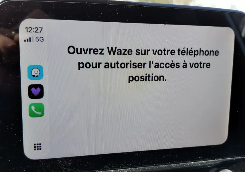 Écran tactile central affichant un message d'autorisation Waze dans une Ford Fiesta gris lunaire, vue rapprochée intérieure.