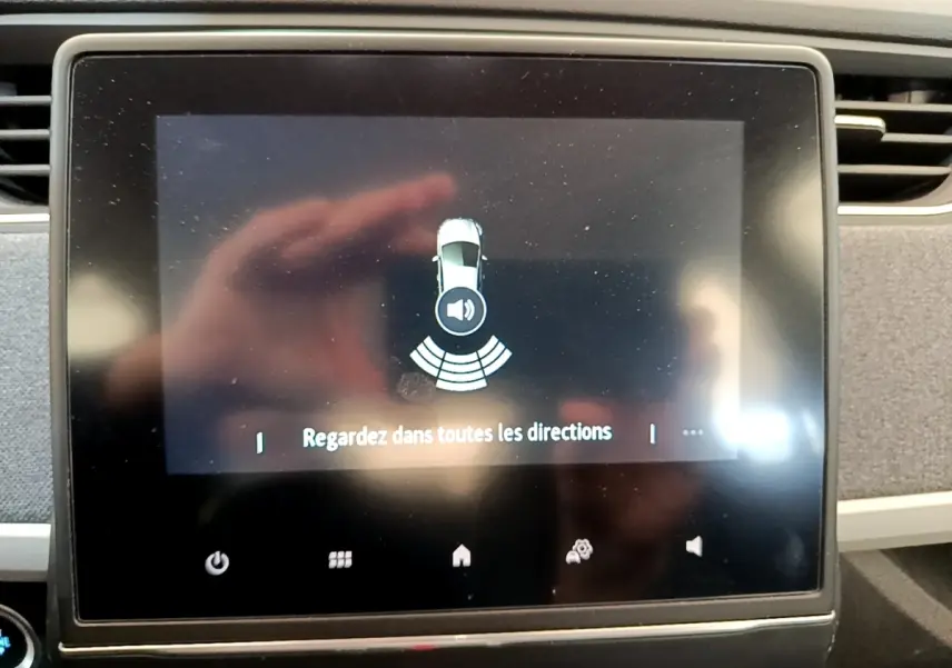Écran tactile central de la Renault ZOE gris clair, affichant l'alerte de surveillance des angles morts.