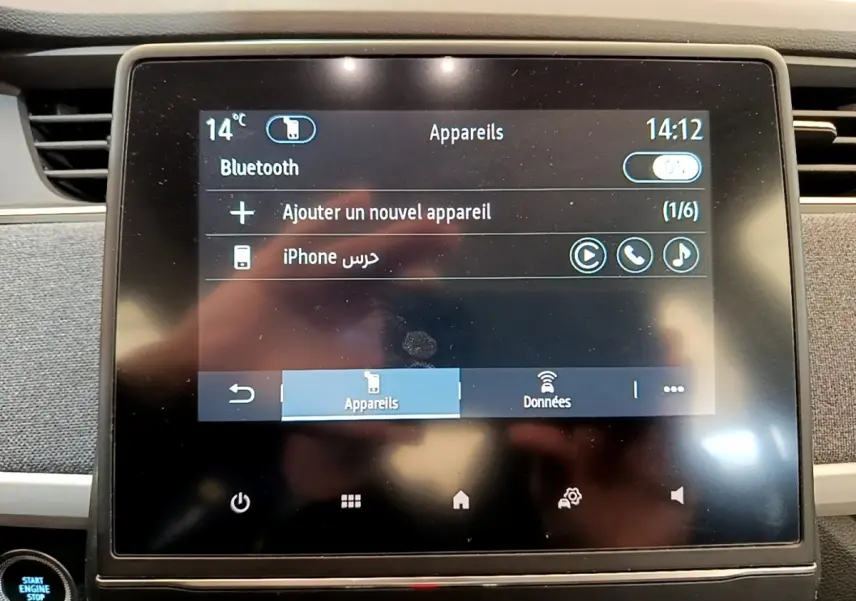 Écran tactile central de la Renault ZOE gris clair, affichant la connexion Bluetooth avec un iPhone.
