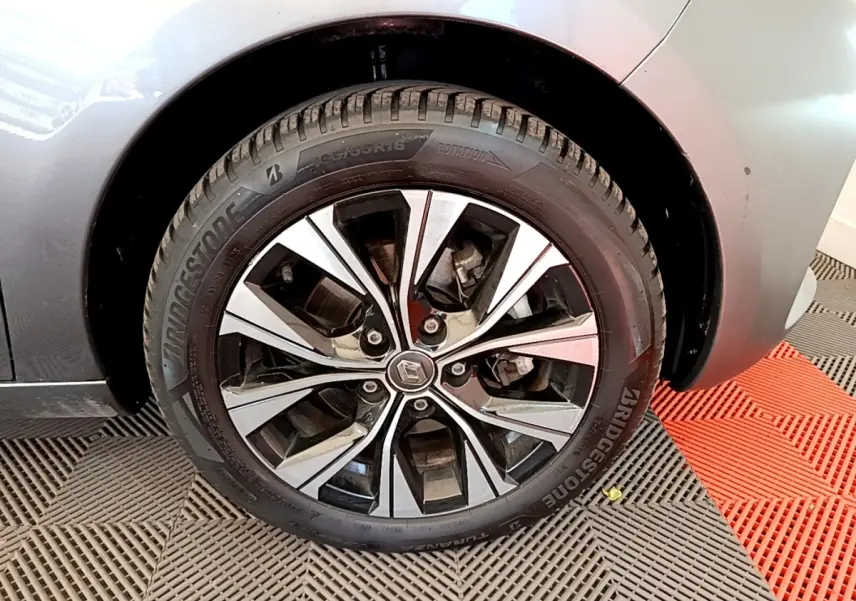 Gros plan sur la roue avant droite de la Renault ZOE gris clair avec jante alliage au design moderne.