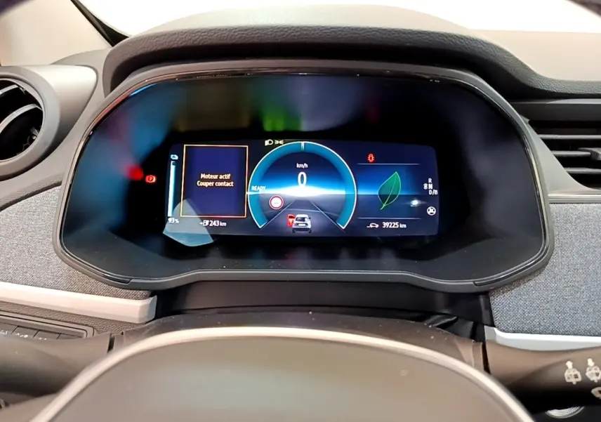 Vue rapprochée du combiné d'instruments numérique de la Renault ZOE gris clair, affichant la vitesse et l'autonomie électrique.