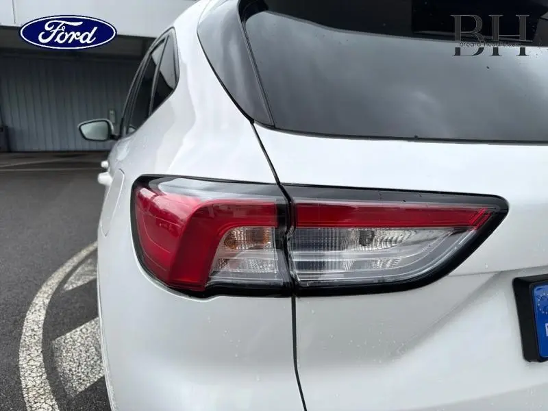 Gros plan sur le feu arrière droit du Ford Kuga 2023 en blanc Premium Platinum avec lunette arrière surteintée.
