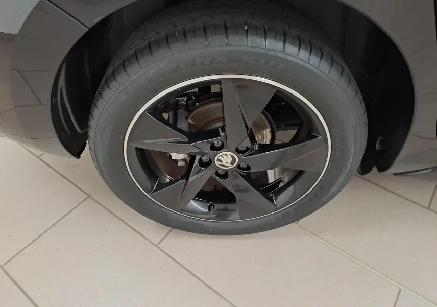 Gros plan sur la roue avant gauche noire brillante avec jante étoile et logo SKODA sur une SKODA SCALA Monte-Carlo 2022.