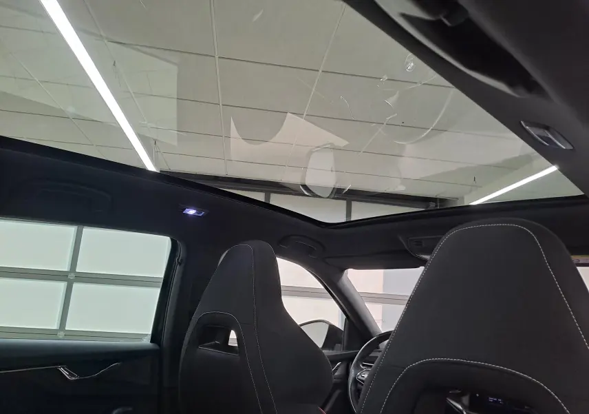 Intérieur du Skoda Scala 2022 noir Magic, vue arrière sur les sièges avant et toit panoramique vitré.