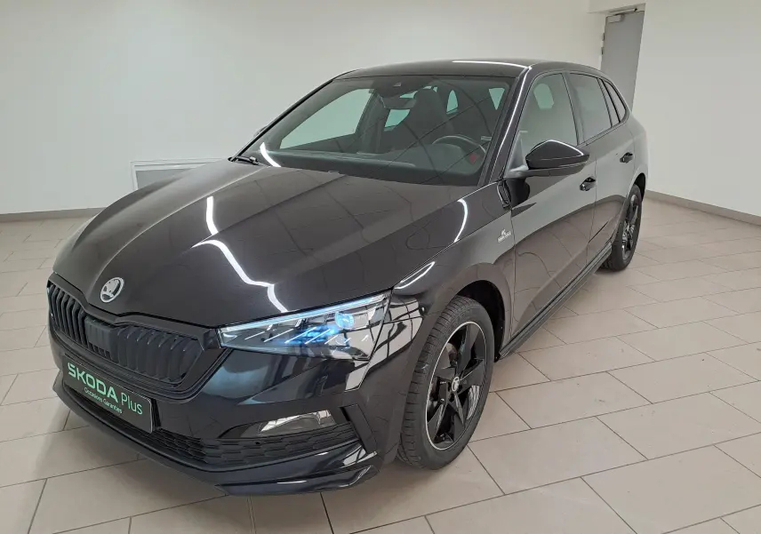 Vue 3/4 avant droite d'une Skoda Scala 1.0 TSI Monte-Carlo noire nacrée avec jantes noires et calandre sombre.