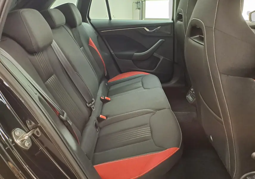 Vue intérieure côté gauche des sièges arrière noirs et rouges de la Skoda Scala 1.0 TSI Monte-Carlo 2022 en Noir Magic Nacré.