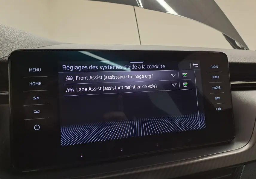 Écran tactile central du Skoda Scala 2022 montrant les réglages d'aide à la conduite activés, intérieur noir.