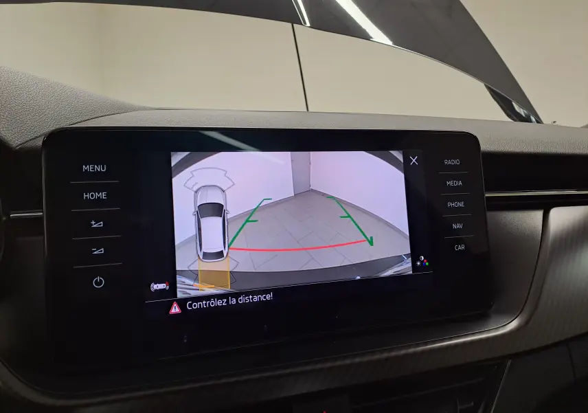 Écran central de la Skoda Scala 2022 montrant la caméra de recul avec lignes de guidage et alerte de distance.