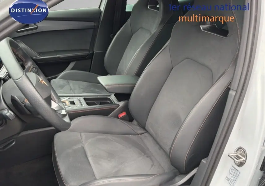 Vue intérieure côté conducteur de la CUPRA Formentor blanc neige, sièges sport en cuir et alcantara avec surpiqûres orange.