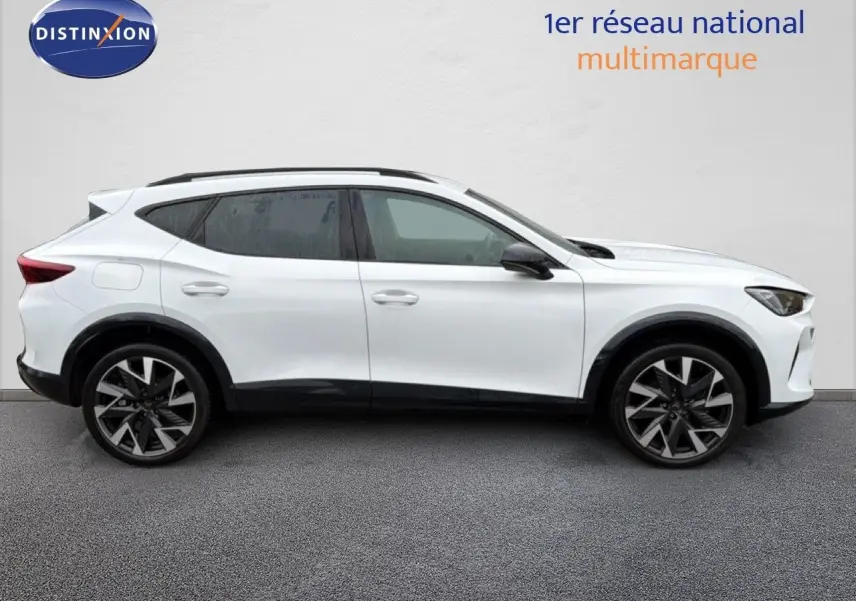 Vue latérale gauche d'un CUPRA Formentor blanc neige métal 2025 avec jantes bi-ton et toit noir.