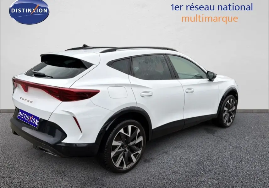 Vue 3/4 arrière droit d'un CUPRA Formentor blanc neige métal avec jantes bi-ton et détails noirs contrastants.