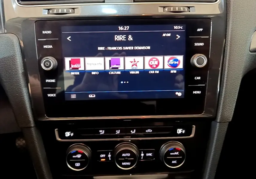 Vue rapprochée de la console centrale noire de la Volkswagen Golf 2019 avec écran tactile et commandes de climatisation.