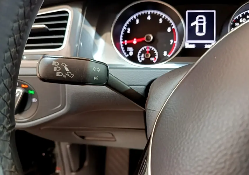 Gros plan sur le volant cuir et le combiné d'instruments de la Volkswagen Golf 1.0 TSI 115 DSG7 Connect, intérieur noir.