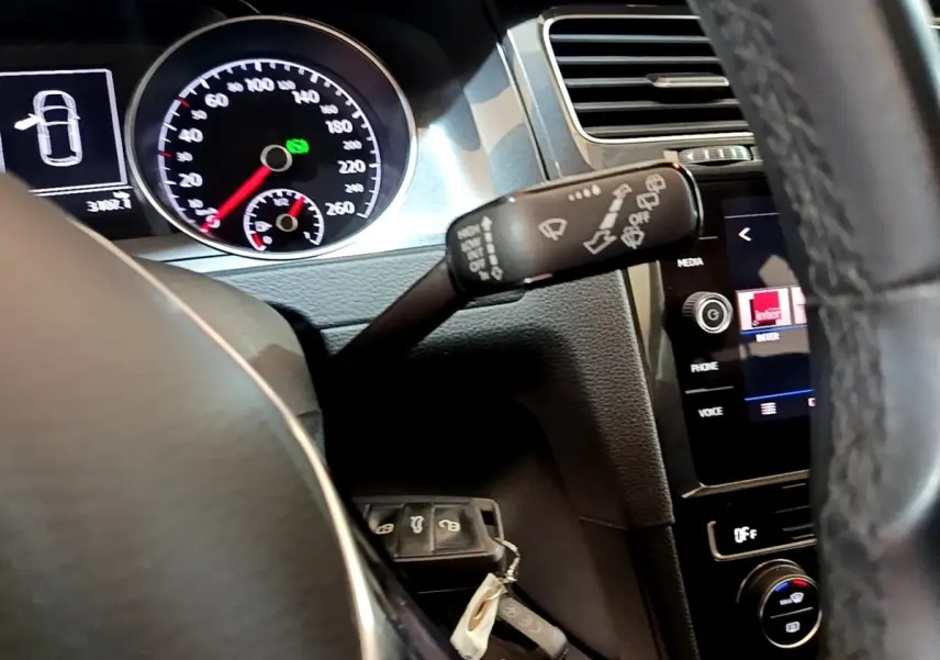 Vue intérieure du tableau de bord de la Volkswagen Golf noir, avec volant cuir et compteur digital lumineux.