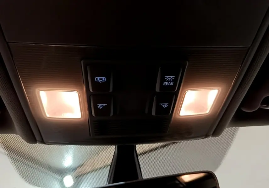 Plafonnier intérieur allumé avec commandes d’éclairage et rétroviseur dans une Volkswagen Golf noire de 2019.