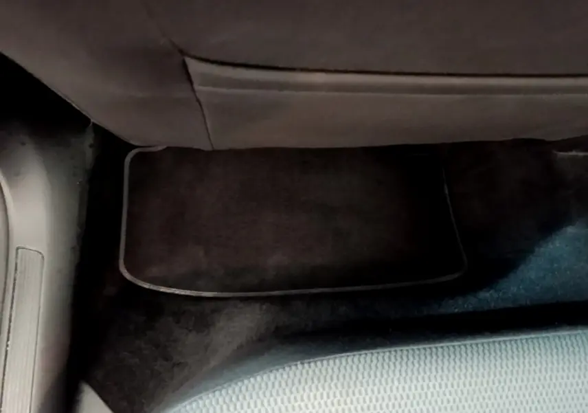 Vue rapprochée du tapis de sol noir sous le siège arrière côté gauche d’une Volkswagen Golf noire de 2019.
