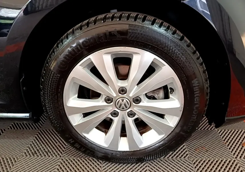 Gros plan sur la roue avant droite d’une Volkswagen Golf noire avec jante argentée et pneu Continental hiver.