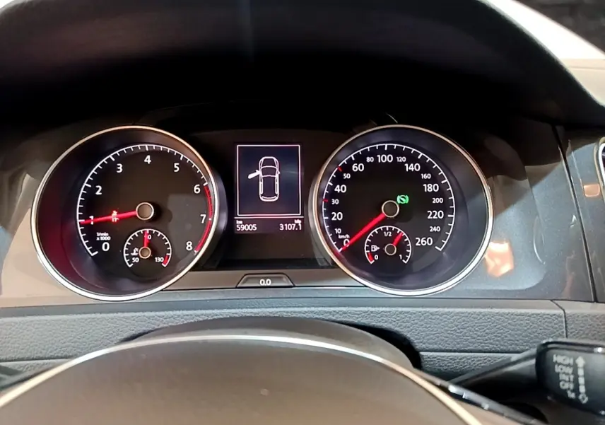 Vue rapprochée du tableau de bord de la Volkswagen Golf noire, affichant les compteurs et l'écran central numérique.