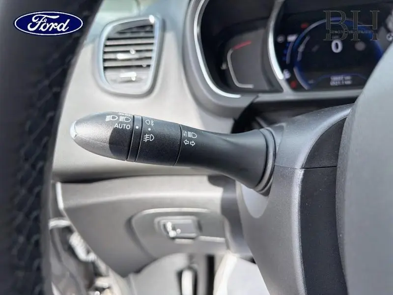 Gros plan sur la commande des phares et clignotants dans un Renault Grand Scenic gris Cassiopée, intérieur noir.