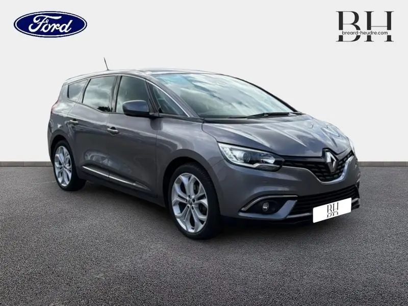 Renault Grand Scénic gris Cassiopée en 3/4 avant droit, montrant ses lignes fluides et jantes alliage.