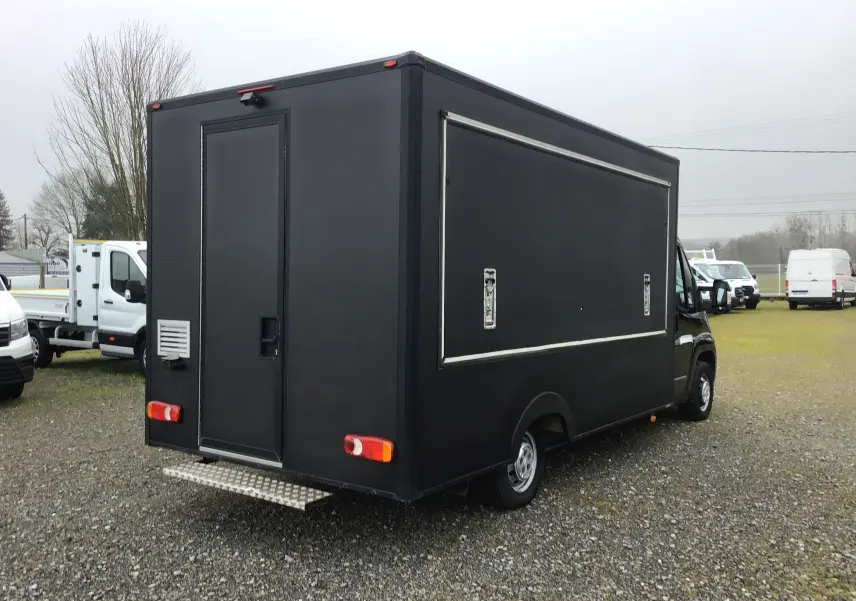 Vue 3/4 arrière droite d'un Citroën Jumper gris graphite aménagé en food truck avec ouverture latérale fermée.