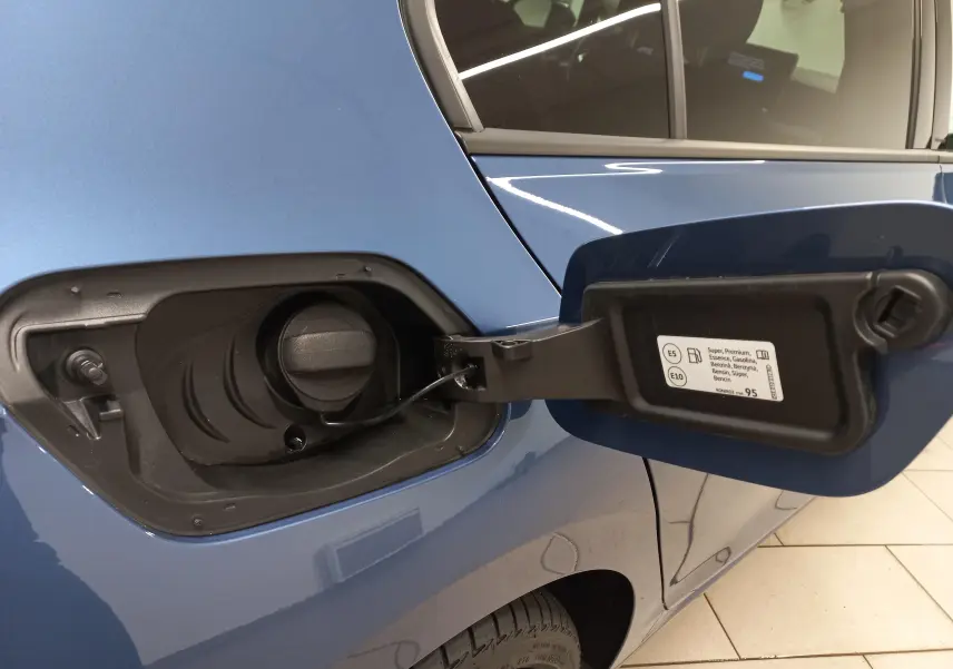 Bouchon de réservoir essence ouvert sur le côté gauche d'une Volkswagen Golf Bleu Anemone avec peinture métallisée.