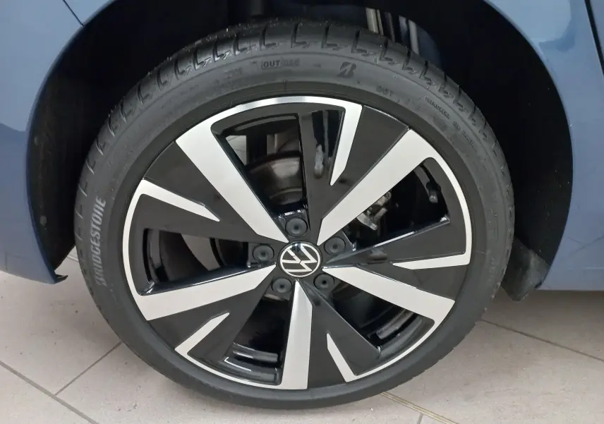 Gros plan sur la jante alliage 18'' Catania bicolore noir et argent d'une Volkswagen Golf Bleu Anemone.