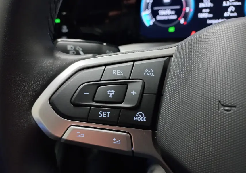 Gros plan sur les commandes de régulateur de vitesse au volant d'une Volkswagen Golf 1.5 TSI 2025.