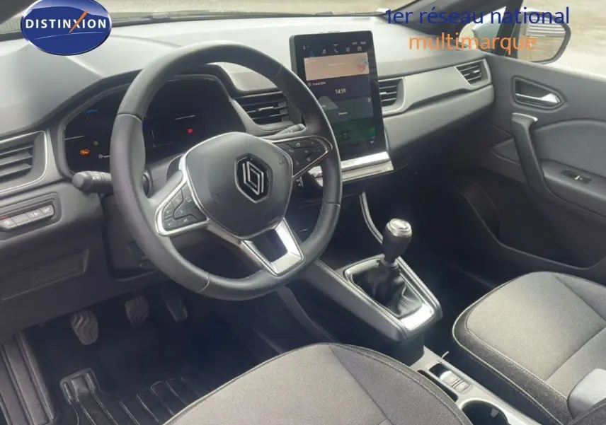 Intérieur avant droit du Renault Captur 2025 noir étoile métal, avec volant cuir, écran tactile vertical et boîte manuelle.