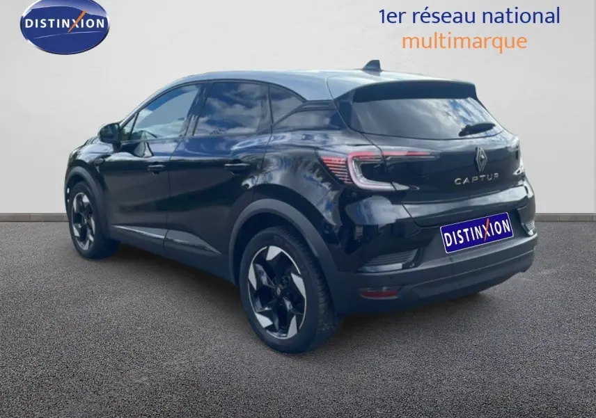 Vue 3/4 arrière d'un Renault Captur noir étoile métal avec toit gris, soulignant ses feux arrière LED et jantes bicolores.