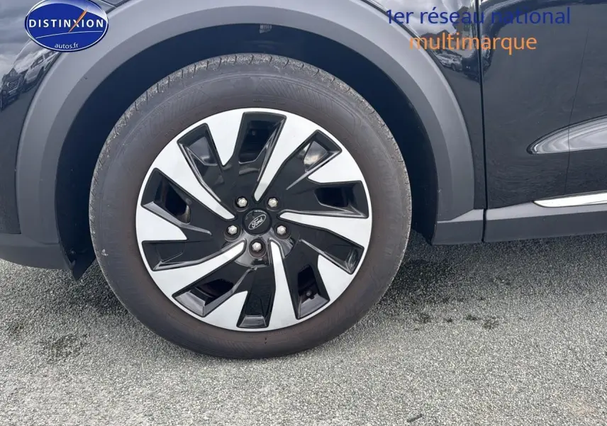 Gros plan sur la roue avant gauche noire du Ford Puma 2023 avec jante bicolore et logo Ford central.