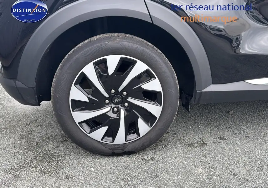 Gros plan sur la roue avant gauche noire du Ford Puma 2023 avec jante bicolore et logo Ford central.