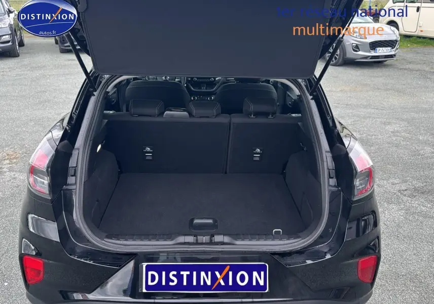Vue arrière d'un Ford Puma noir 2023 avec coffre ouvert et banquette rabattable visible.