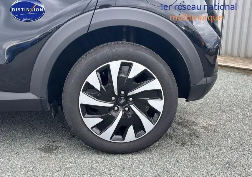 Gros plan sur la roue avant gauche noire avec jante alliage du Ford Puma 2023 finition Titanium.