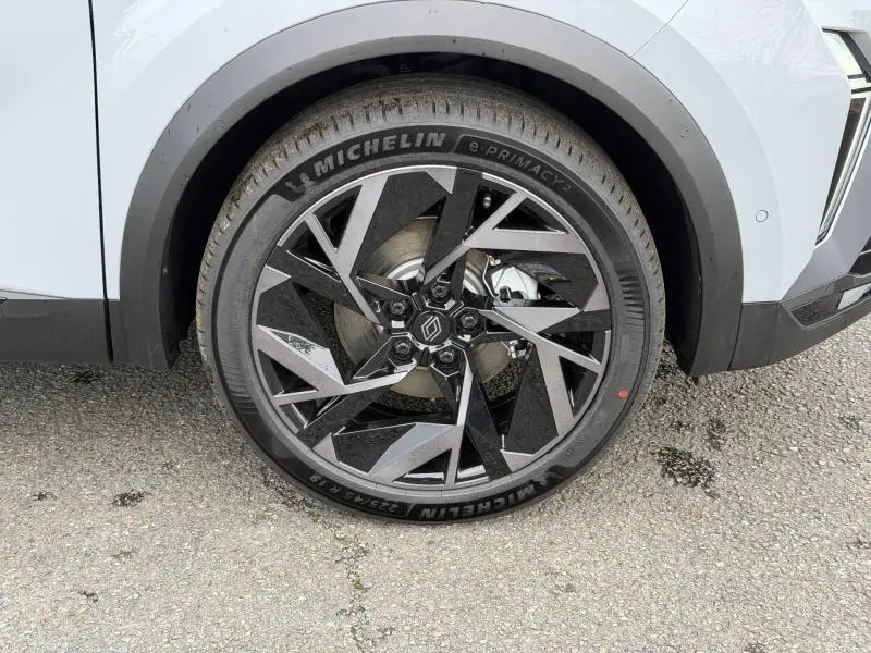 Gros plan sur la roue avant gauche du Renault Captur 2026 gris Rafale, jante alliage noire et argentée au design géométrique.