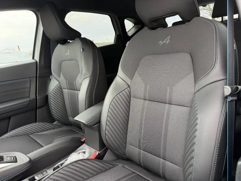 Vue intérieure rapprochée des sièges avant gris du Renault Captur 1.8 E-Tech esprit Alpine avec logo Alpine brodé.