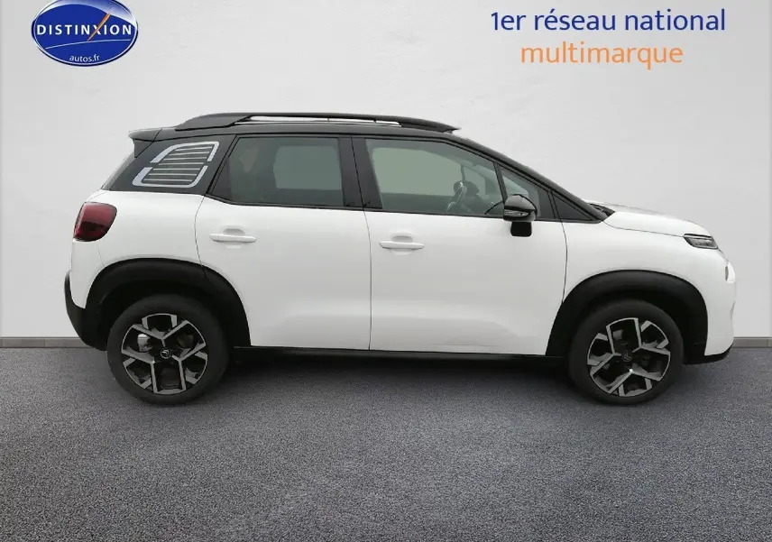 Profil côté gauche d'un Citroën C3 Aircross blanc polar avec toit noir et jantes bi-ton, sur fond neutre.