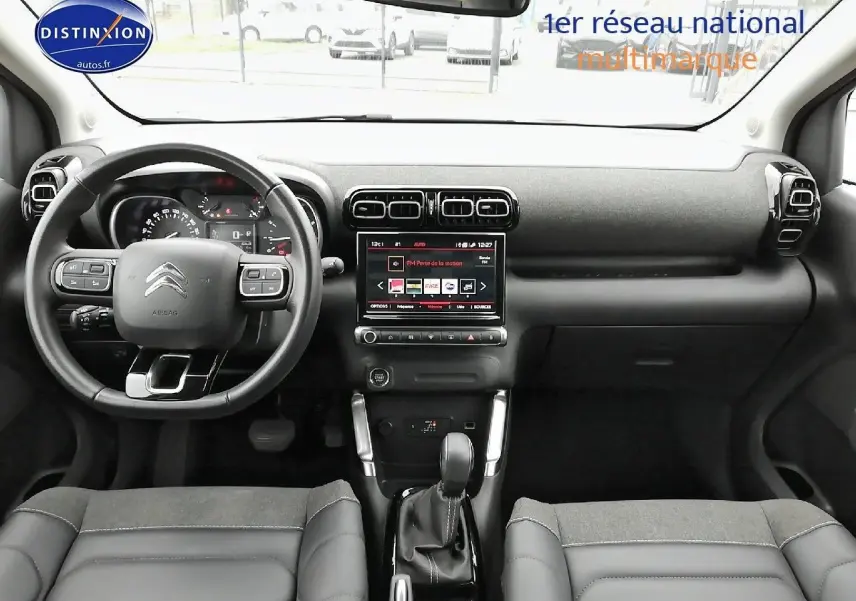 Vue intérieure frontale du tableau de bord et volant noir du Citroën C3 Aircross 2022 avec écran tactile central allumé.