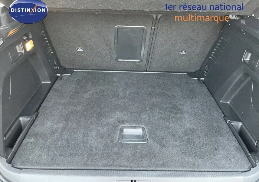 Coffre spacieux du Peugeot 3008 Cooper Metal vu de l'arrière, avec tapis de sol noir et éclairage intérieur allumé.
