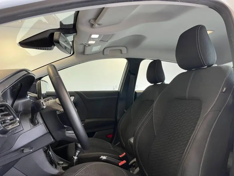 Vue intérieure côté conducteur du Ford Puma 2022, sièges noirs avec surpiqûres blanches et volant multifonction.