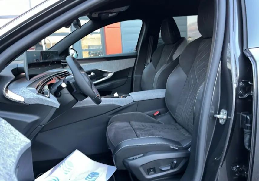 Vue intérieure côté conducteur du Peugeot 5008 Hybrid 145 GT Alcantara avec sièges en cuir et alcantara gris et tableau de bord moderne.