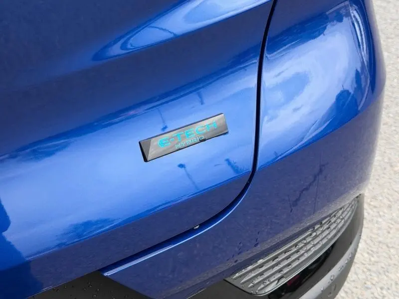 Gros plan sur l'arrière droit bleu Iron du Renault Captur 1.8 E-Tech hybride avec badge E-Tech Hybrid turquoise.