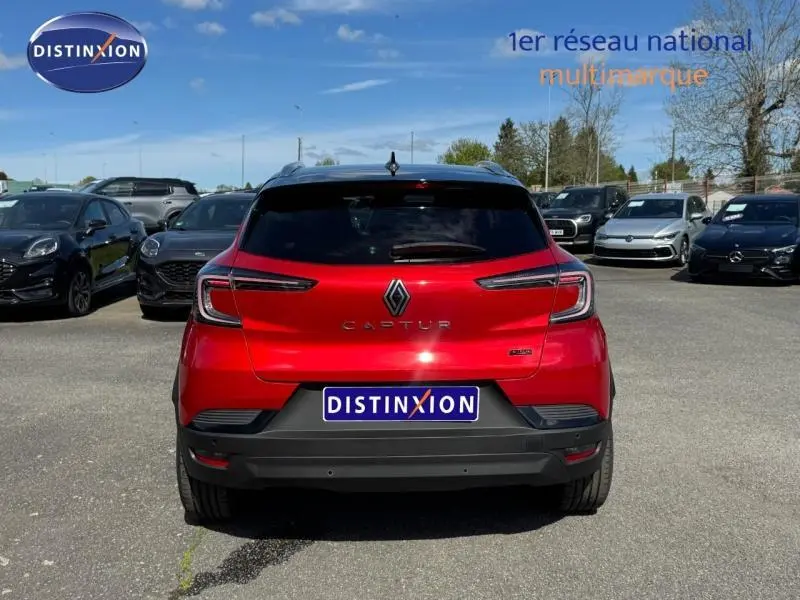 Vue arrière d'un Renault Captur rouge flamme 2025 avec logo et feux arrière LED visibles sur parking.